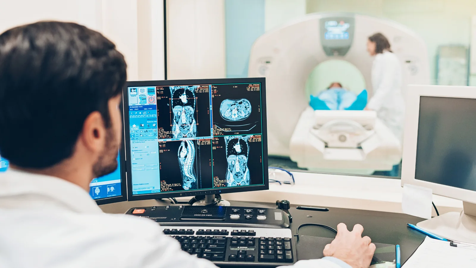 Manipulateur d'électroradiologie médicale devant une console d'imagerie